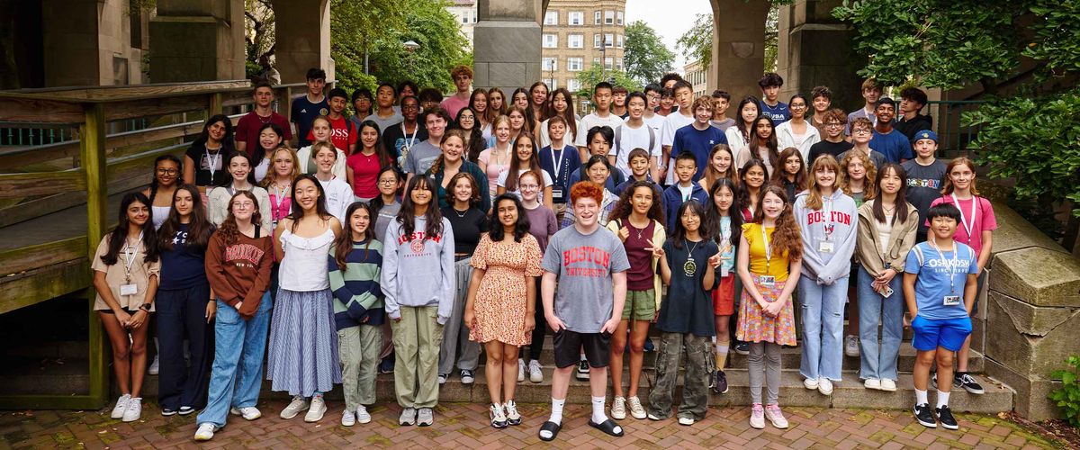 A large group of BU students pose for a group photo on the stairs next to Marsh Chapel
