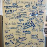 A photo of a whiteboard with "How do you say 'hello' in your language?" written on it, and many entries in different languages