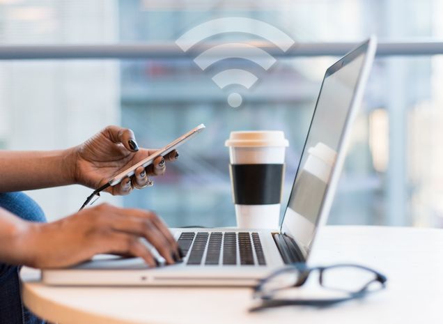 Image of person connecting phone and laptop to wireless internet