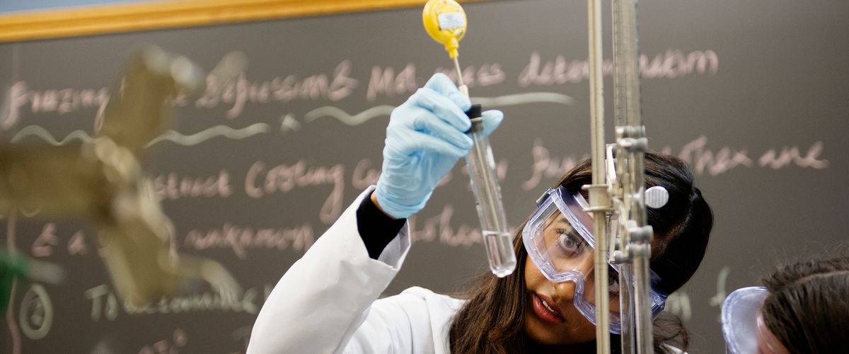 Student examines a science beaker.