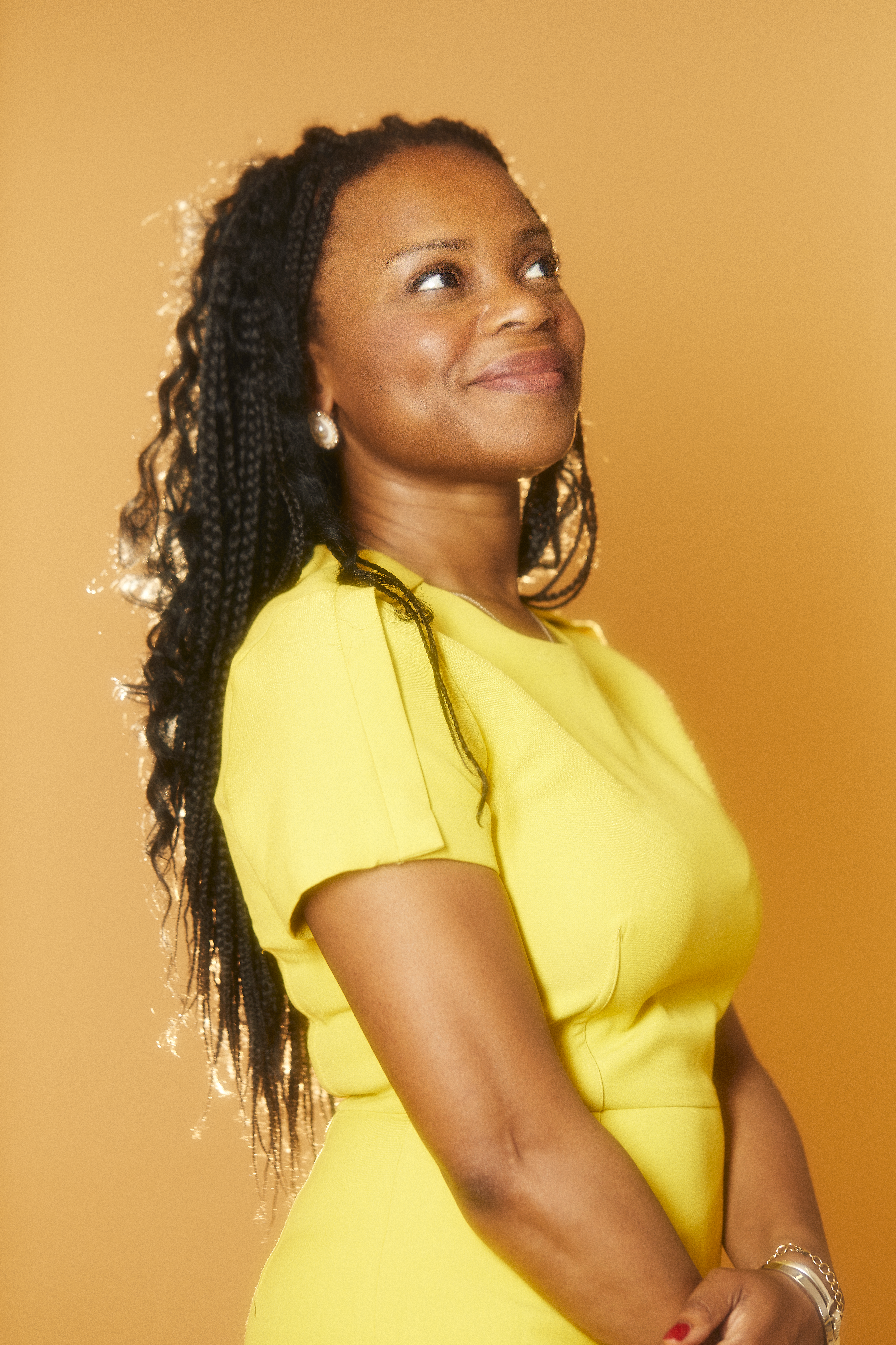 Portrait of black women in yellow dress looking out into the distance