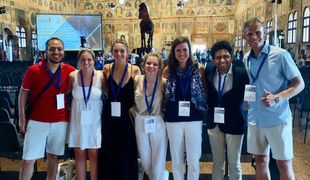 Shows professor and six graduate students at conference