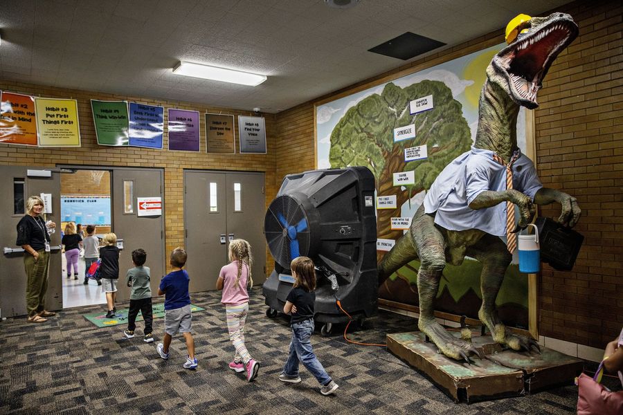 Children walking along a school hallway toward the cafeteria