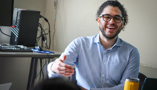 show faculty member speaking to group of students