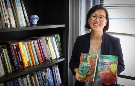 Shows faculty member Grace Kim holding two books
