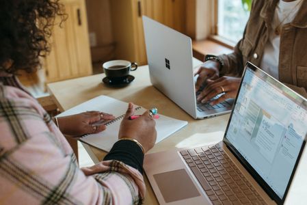 A photo of someone sitting at a computer and writing
