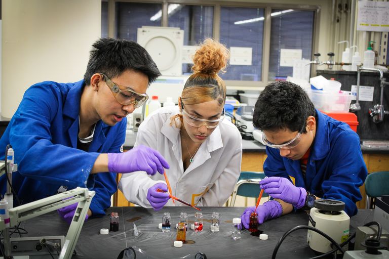 Shows three high schools students in a science lab