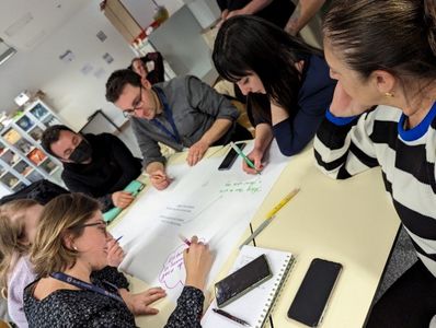 Shows five teachers working at a table