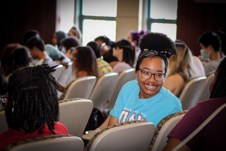 Young girl looks backward smiling at classmates