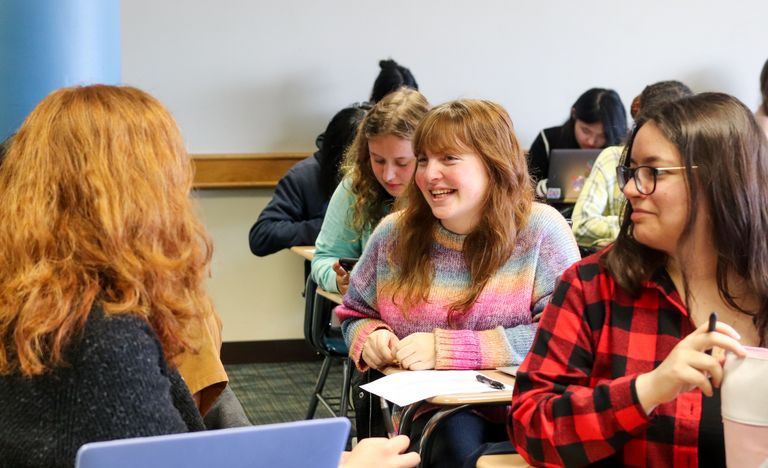 Undergraduate students talking in class