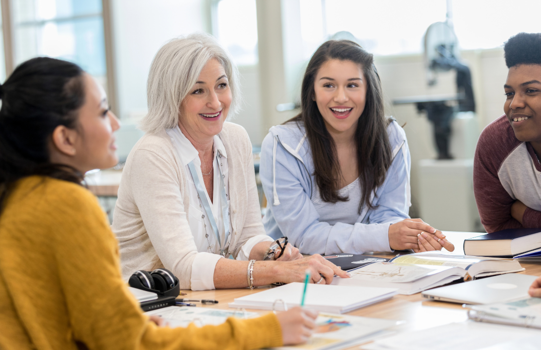 older female teacher review material with her students