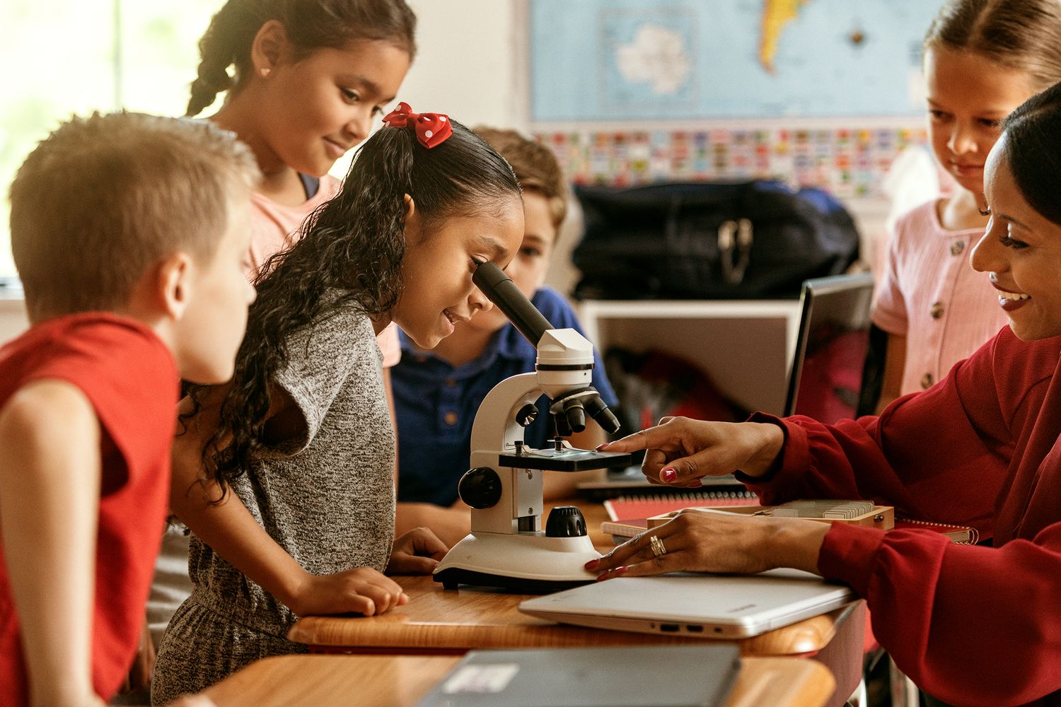 children looking into a microscope during a class