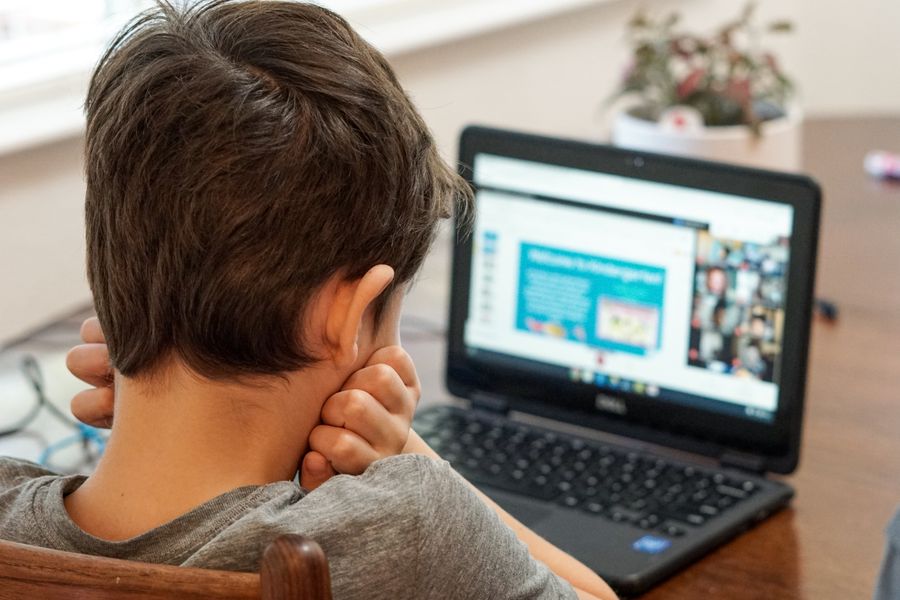 A boy sits at a computer