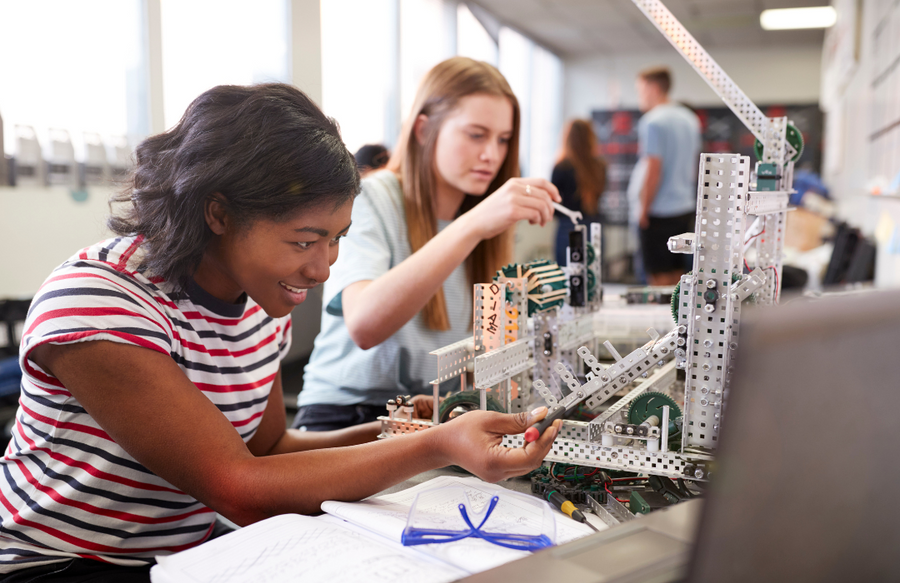 Two students work on a metal structure in a stem based class