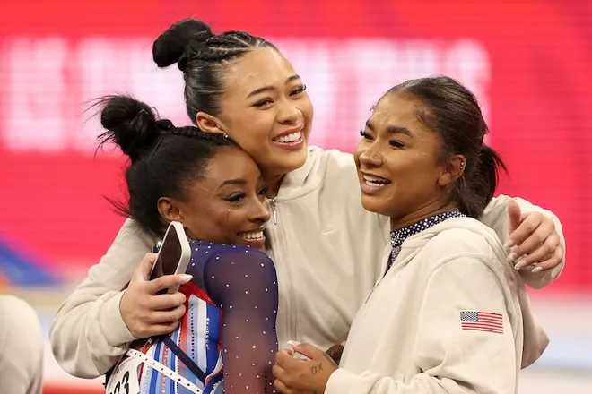 A photo of Simone Biles hugging her teammates.