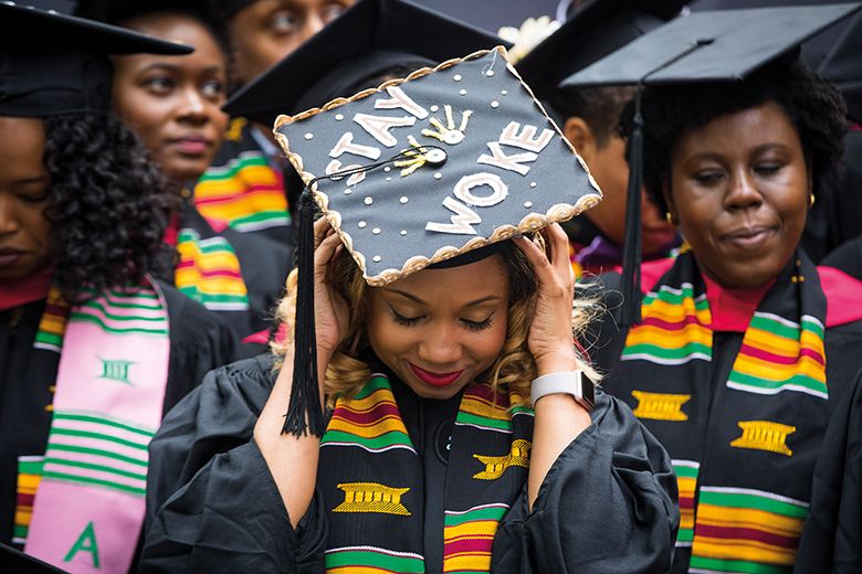 A woman at Harvard Black Commencement wearing a graduation cap that says "Stay Woke"