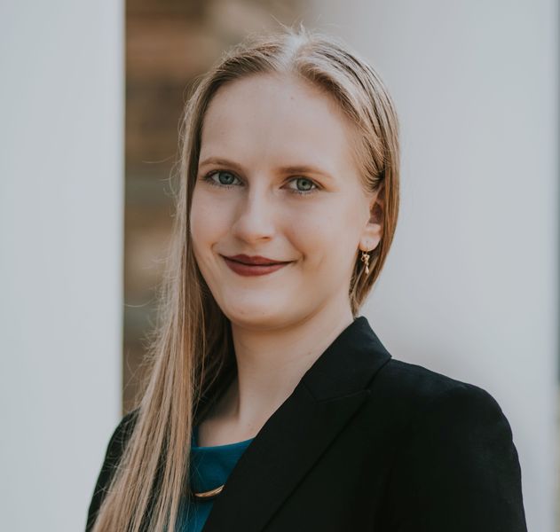 Shows Katherine Szocik who has long blond hair and is wearing a dark jacket