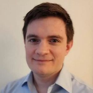 Shows Matthew Sullivan, who has short brown hair and is wearing a light blue collared shirt