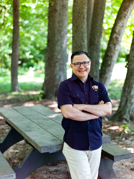 Jeremy Buzzell in nation parks button down smiling infront of picnic bench