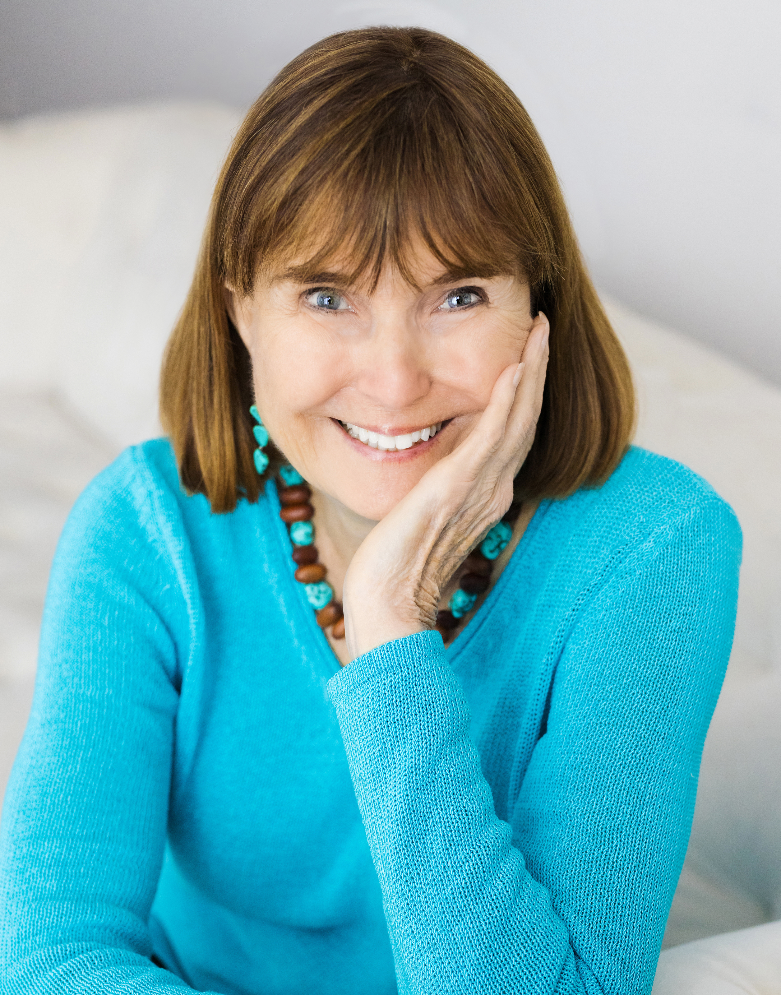 Jean Kilbourne smiling with dark brown hair and a bright blue sweater