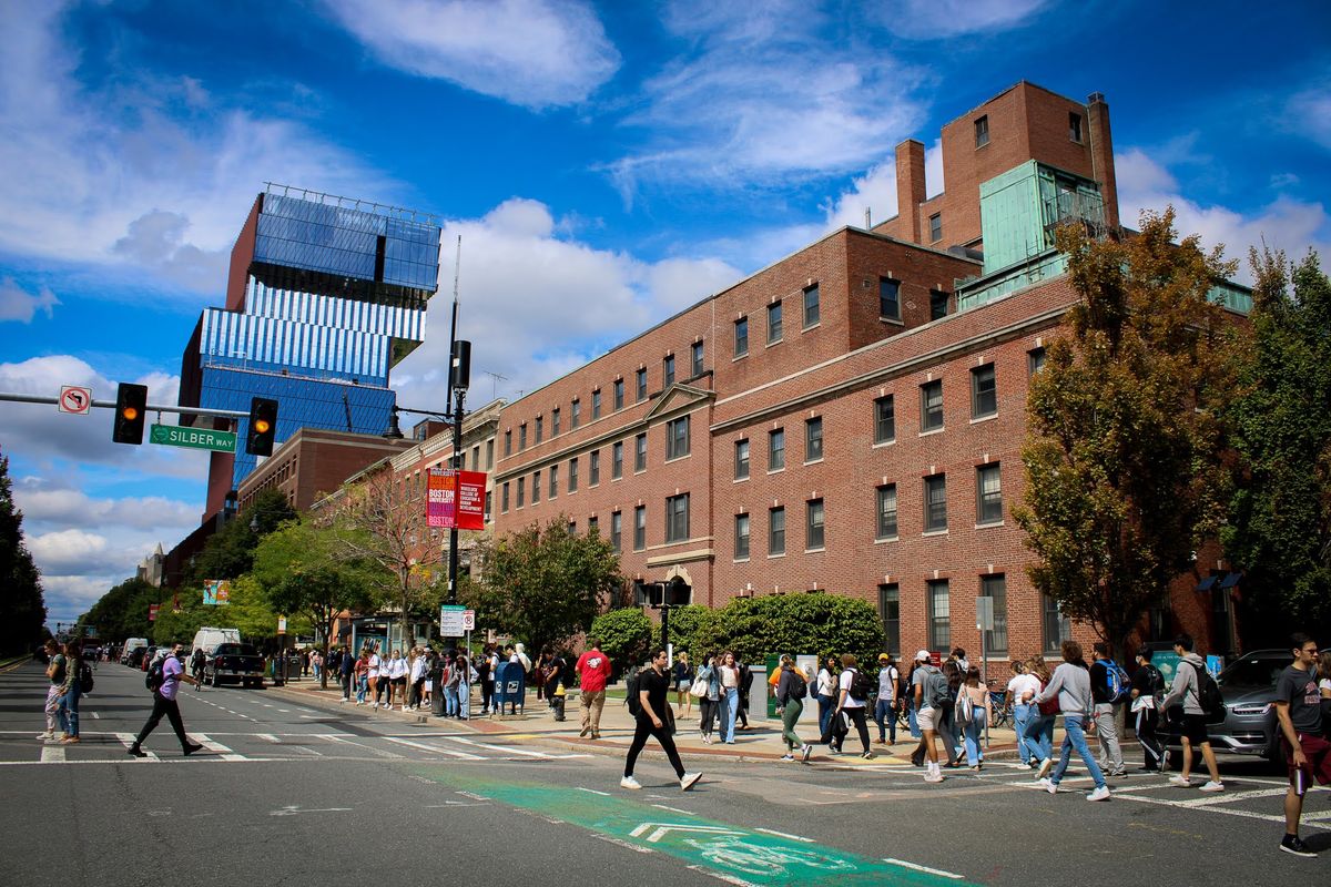 building photo of large brick building with people walking on the street infront of it in the city of Boston