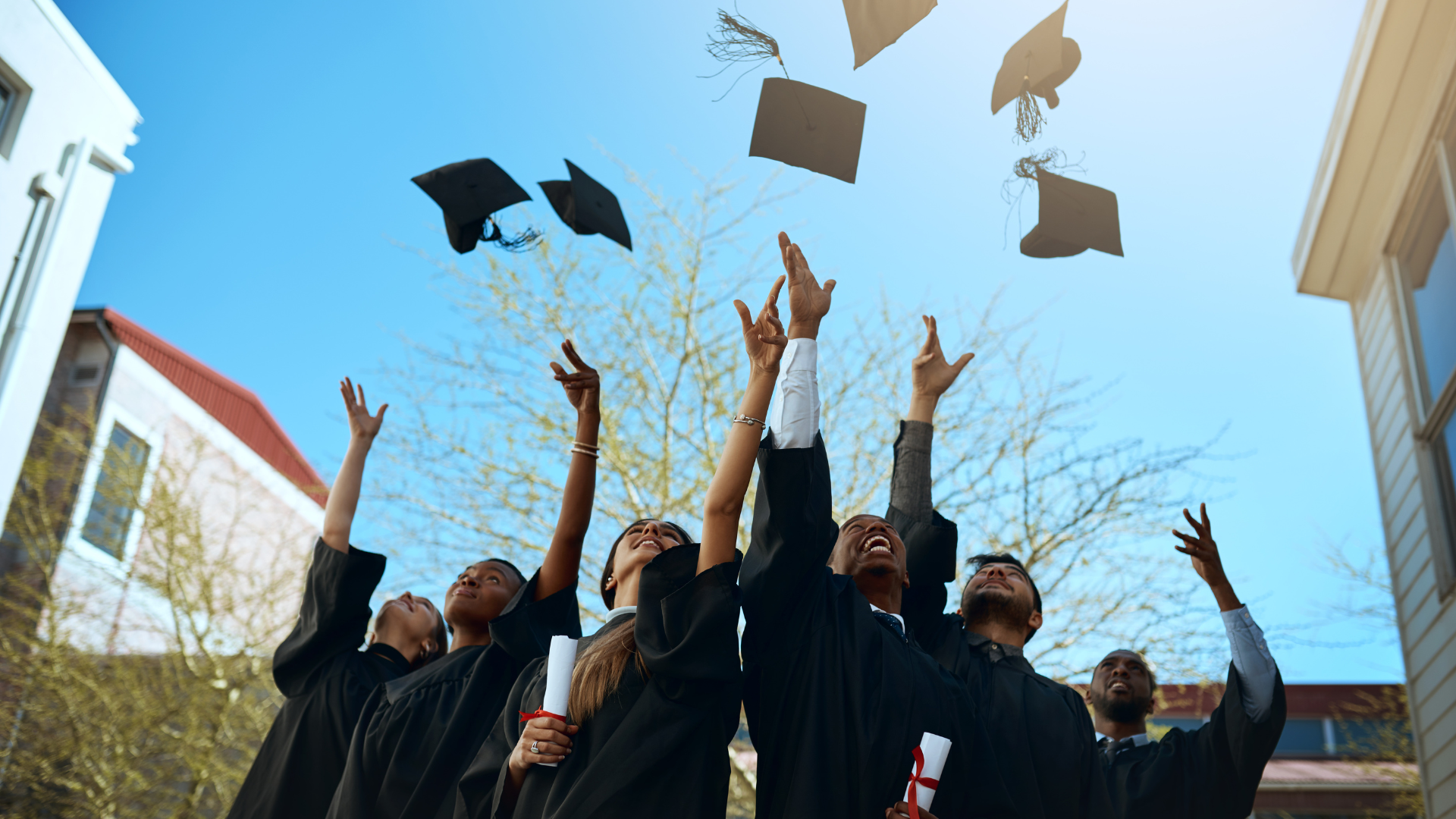 a group of graduates tossing their caps into the air