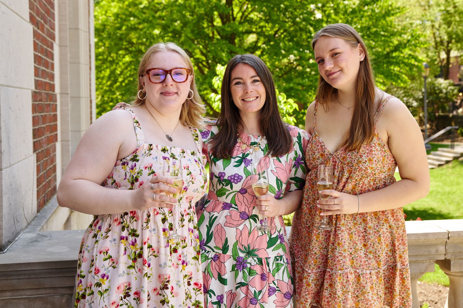 Three women stand together outside