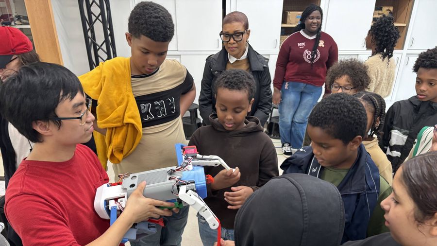 Elementary school students on a visit to BU learn about robotics from a BU doctoral student