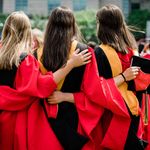 3 graduate students with interlocked arms from behind