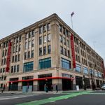 Corner view of Fuller Building, where LGBTQIA+ Center is located, with vertical banners that say Boston University.