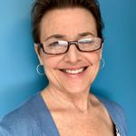 smiling white woman in front of blue background