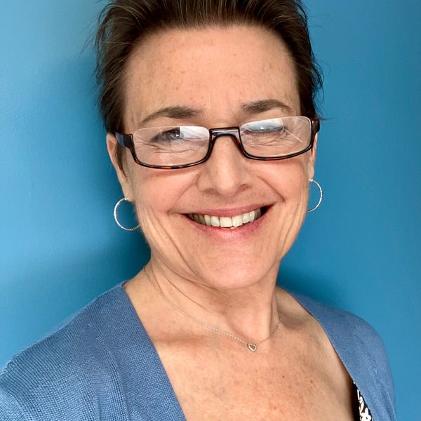 smiling white woman in front of blue background