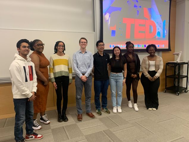 eight BU students standing in front of a big screen